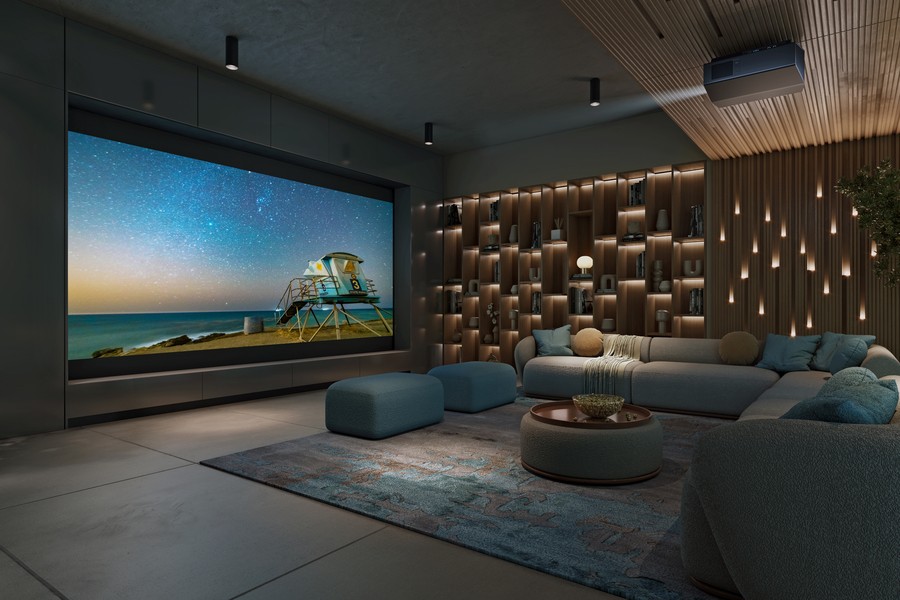 A casual home theater with a sectional, soft lighting, a large screen, and a Sony projector.