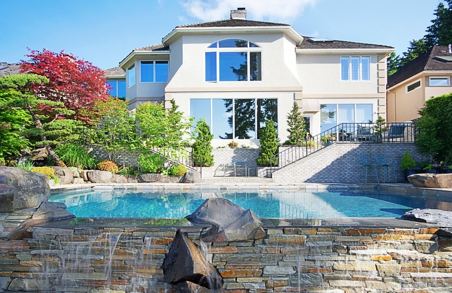 Image is of a modern home with a pool outside.