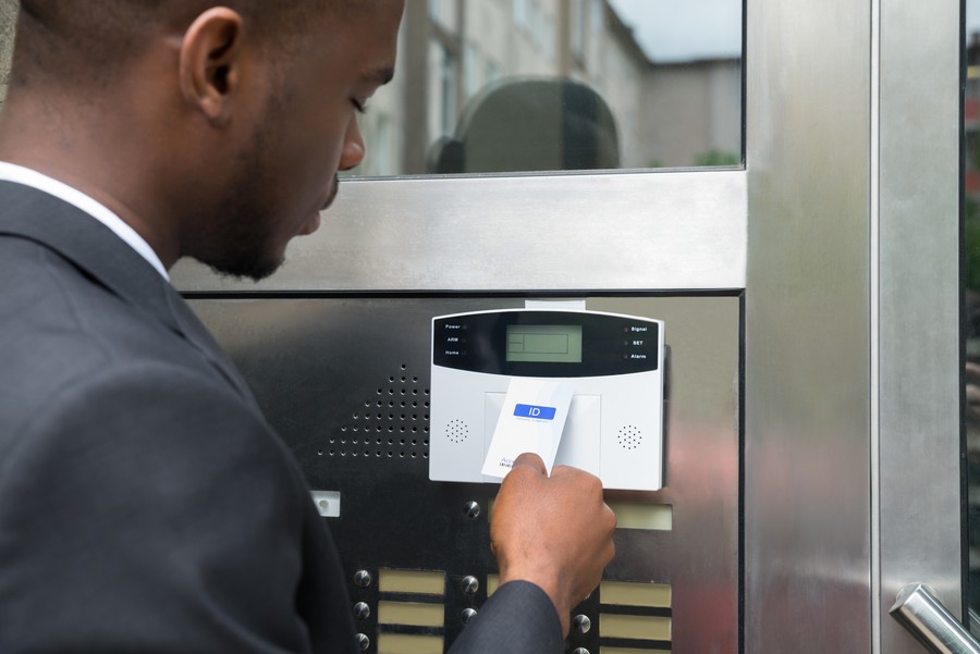 Photo is of an employee using a key card to enter a commercial business.