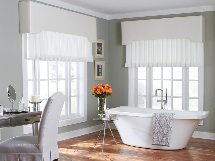 A classic bathroom with a wood floor, soaking tub, and white window treatments.