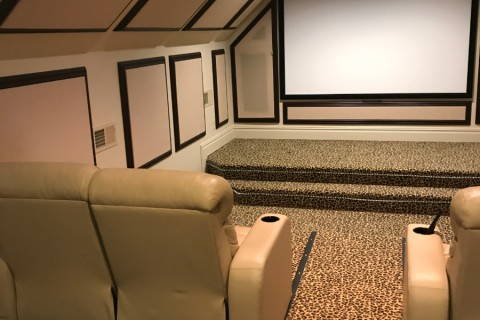 A home theater setup with luxury reclining chairs.