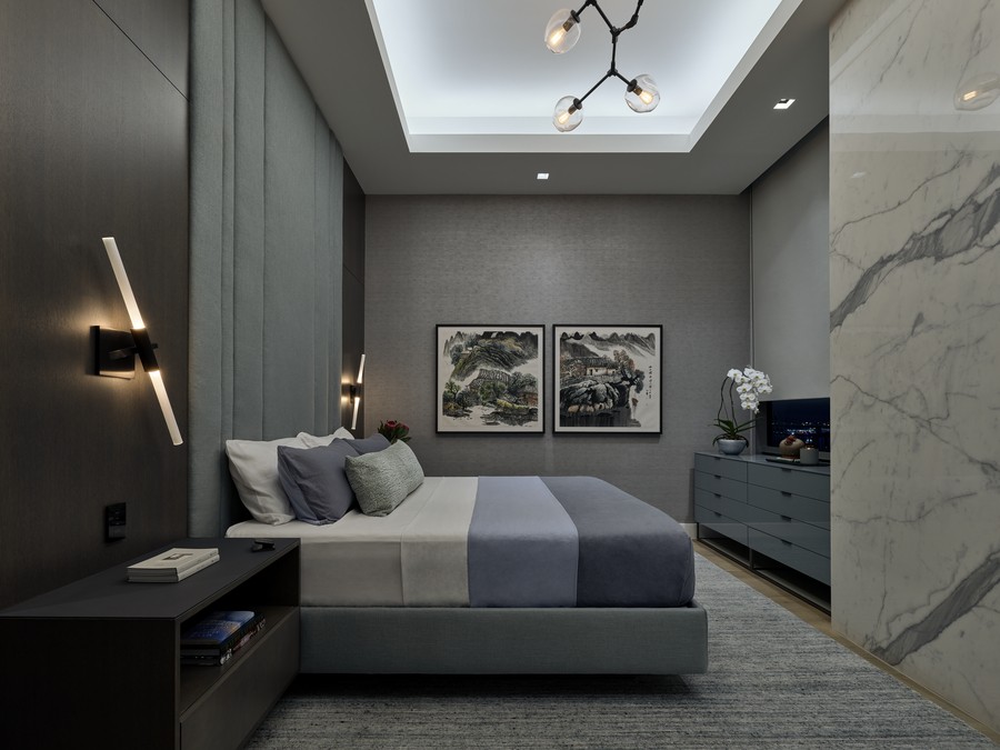 Bedroom with intriguing bedside light fixtures, recessed downlights and hanging chandelier fixture.