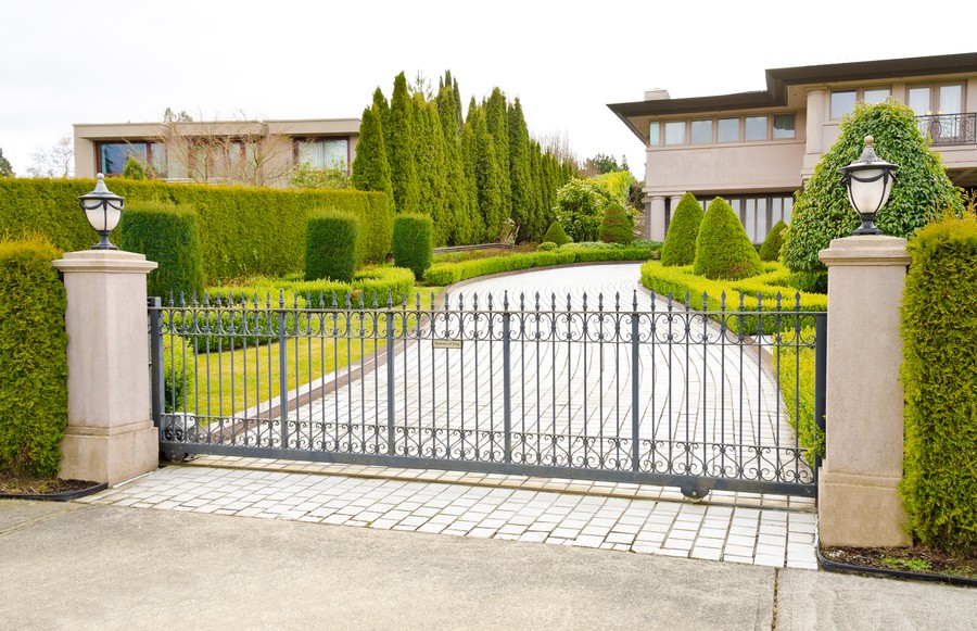 A New Orleans-style front gate to a driveway of a luxury home.