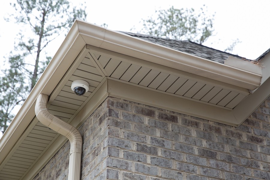 The corner of a brick home featuring a Luma surveillance camera.