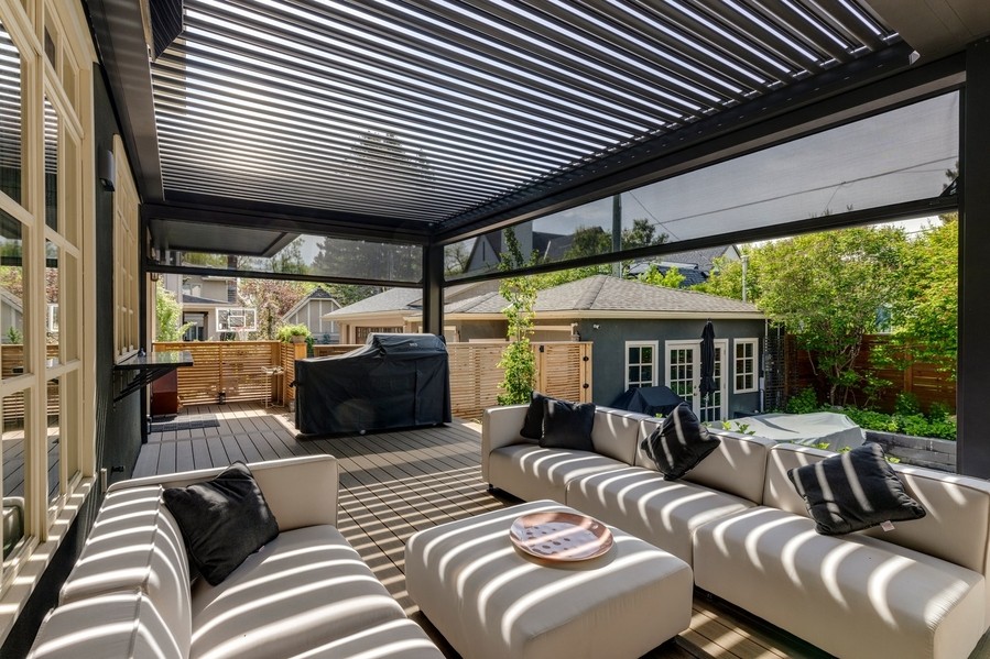 A back porch with outdoor motorized shades lowered partially.