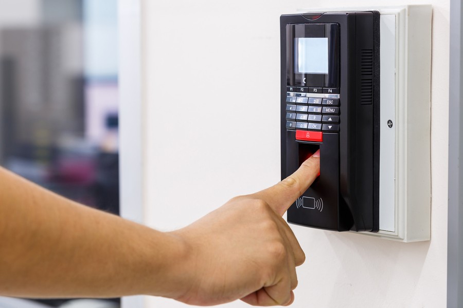 Closeup of a man scanning his fingertip on a biometric access control point. 