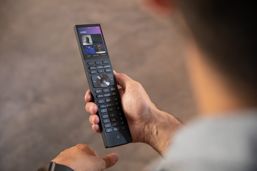 A man uses a Control Halo remote to choose AV content.